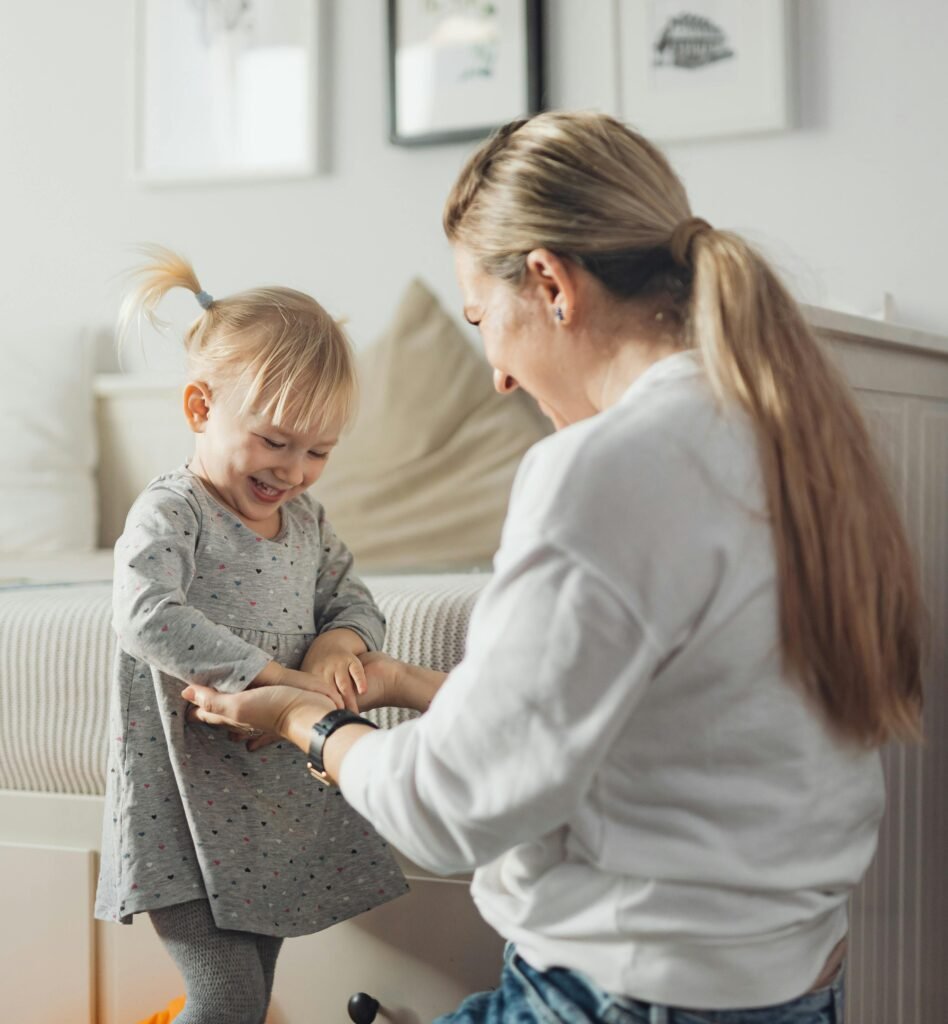 Mother smiling and playing with her toddler during the weaning stage.